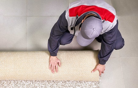 male worker unrolling carpet floor home view from optimized